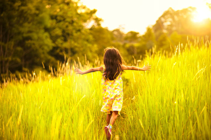Kind läuft durch hohes Gras